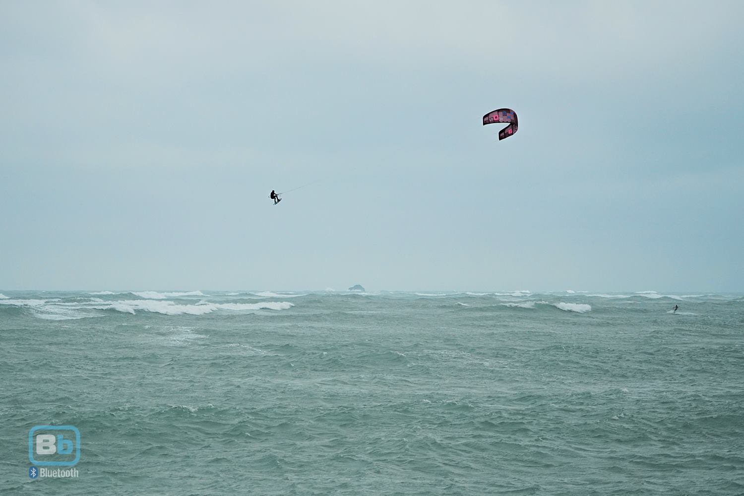 Kitesurfer sending a big air kiteloop with big kickers waves and strong wind conditions in Penghu, Taiwan.